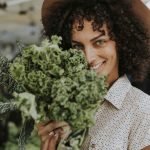 Beautiful woman buying kale at a farmers market